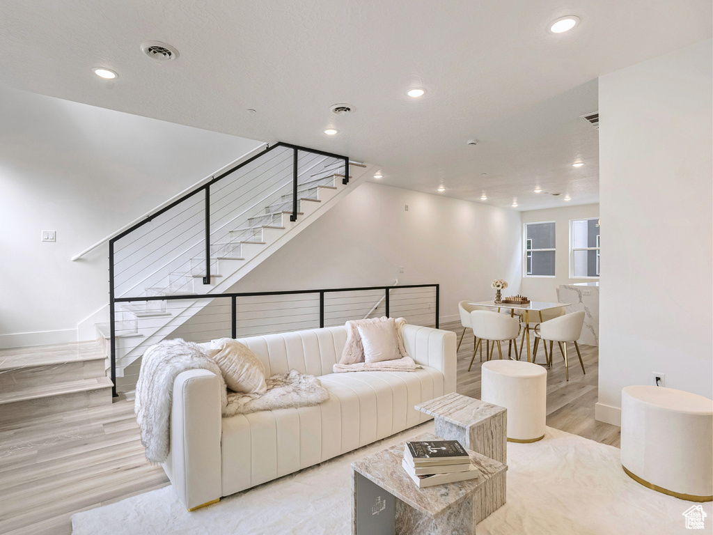 Living area with stairs, recessed lighting, baseboards, and visible vents