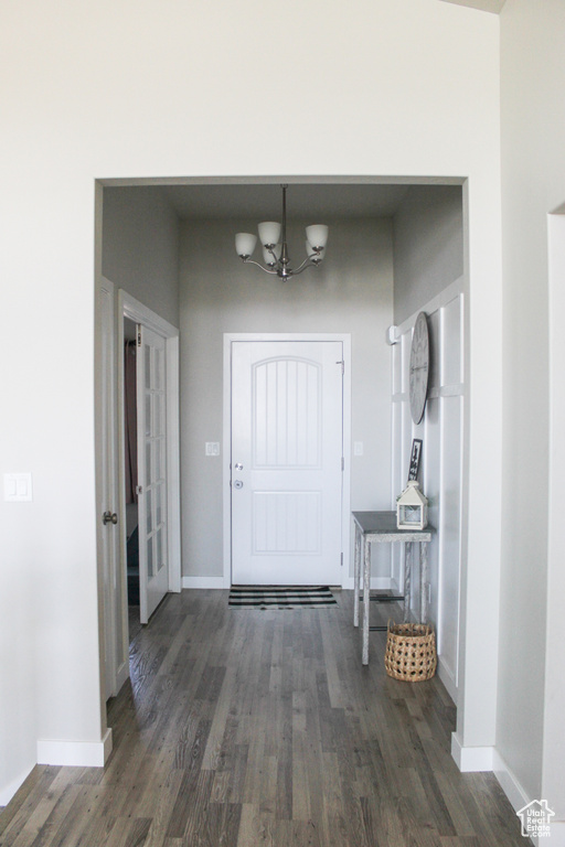 Entrance foyer featuring a chandelier, wood finished floors, and baseboards
