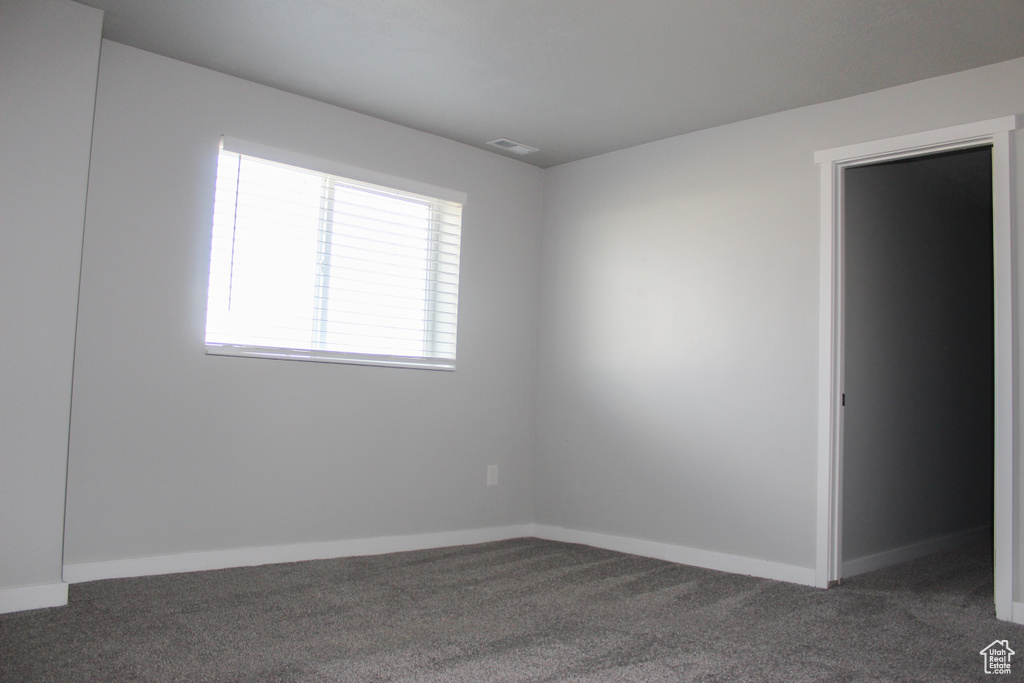 Carpeted empty room featuring baseboards