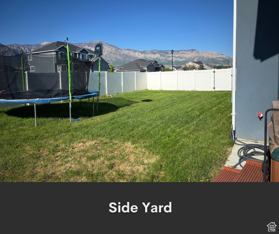 View of yard featuring a trampoline and a mountain view