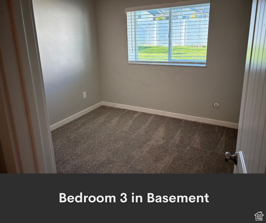 Spare room featuring carpet floors and baseboards