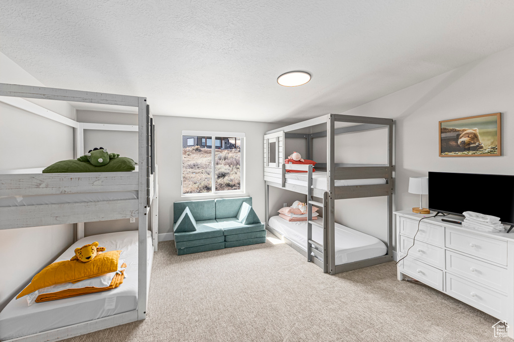 Bedroom featuring a textured ceiling and light carpet