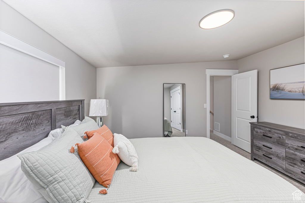 Carpeted bedroom with baseboards and visible vents