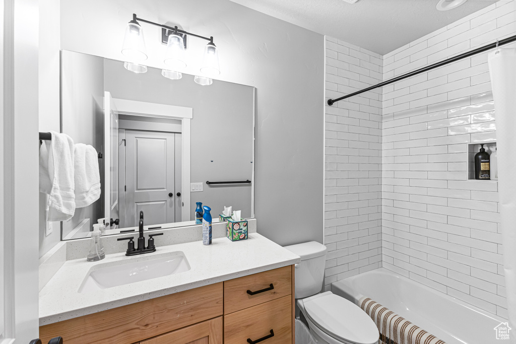 Bathroom featuring shower / bath combination, vanity, and toilet