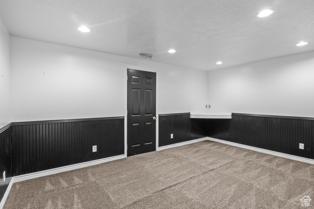 Spare room featuring a textured ceiling, visible vents, wainscoting, carpet, and recessed lighting