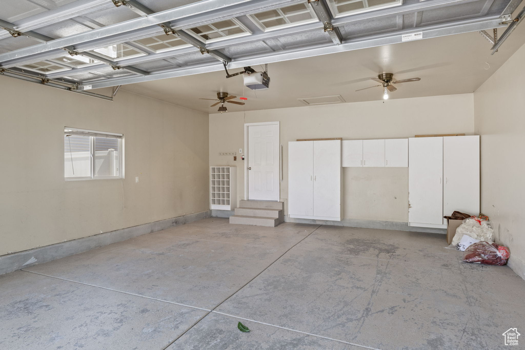 Garage featuring ceiling fan and a garage door opener