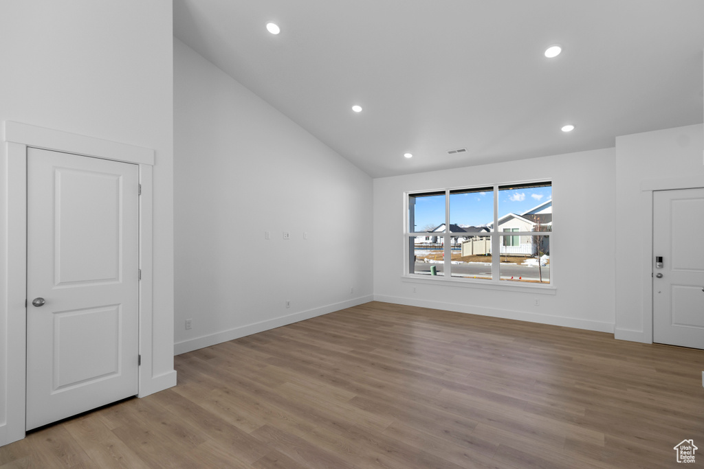 Interior space featuring recessed lighting, baseboards, light wood finished floors, and lofted ceiling