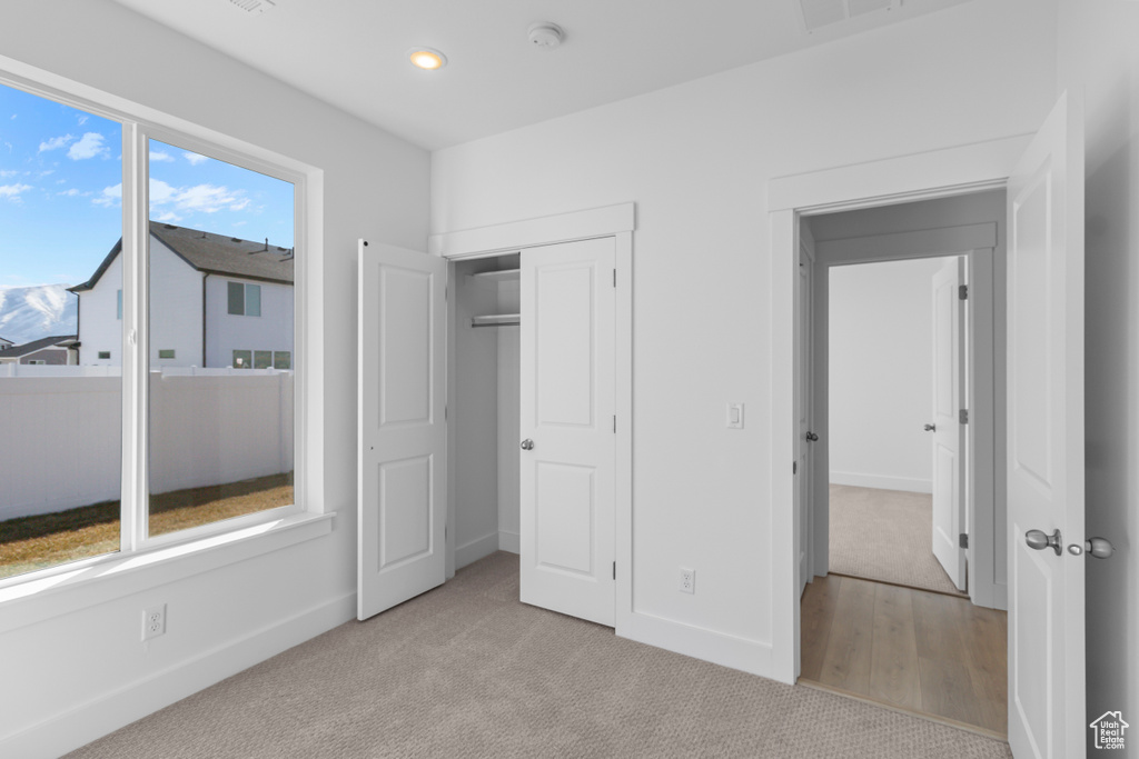 Unfurnished bedroom featuring baseboards, light carpet, and recessed lighting