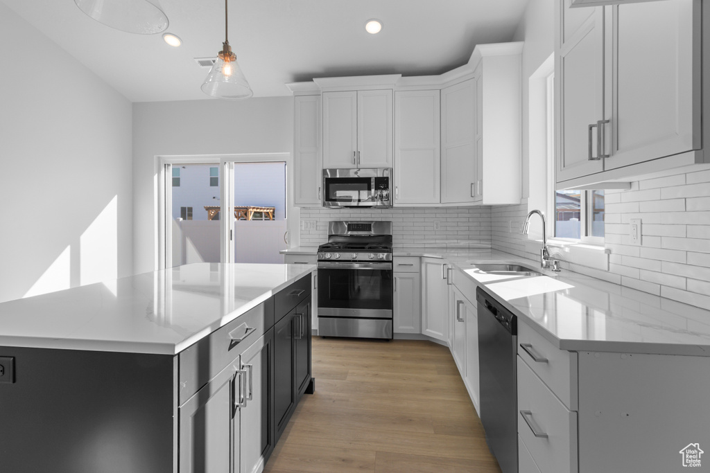 Kitchen featuring stainless steel appliances, recessed lighting, a sink, and tasteful backsplash
