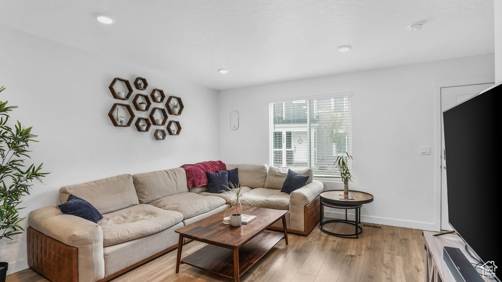 Living room with recessed lighting, baseboards, and light wood finished floors