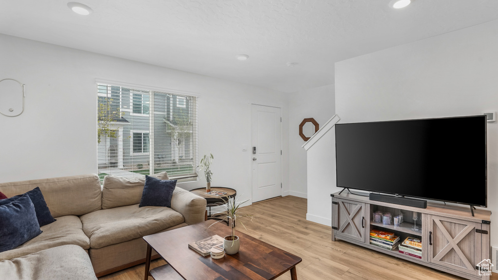 Living room with recessed lighting, light wood-style flooring, and baseboards