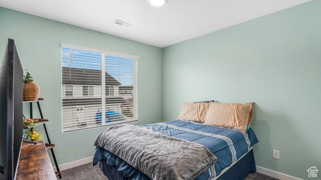 Bedroom with baseboards, visible vents, and carpet