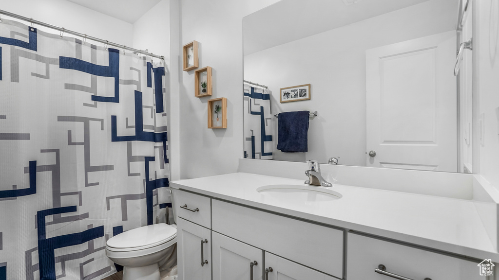 Bathroom featuring vanity, a shower with curtain, and toilet