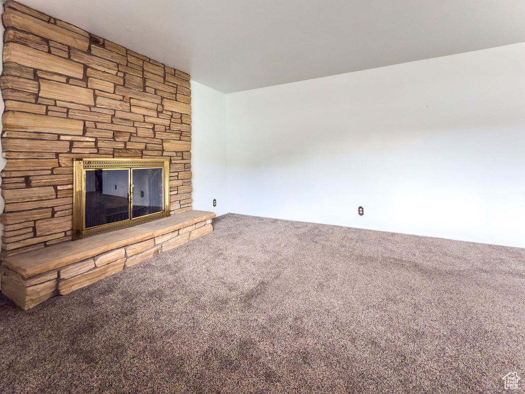 Unfurnished living room with carpet floors and a fireplace