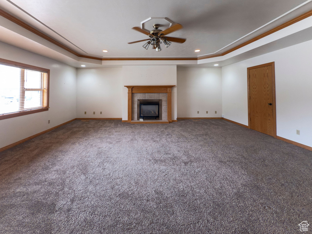 Unfurnished living room featuring a raised ceiling, ceiling fan, carpet, and recessed lighting