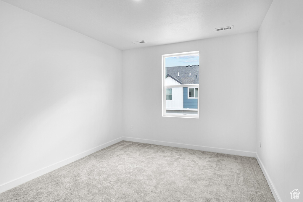Carpeted spare room with baseboards and visible vents