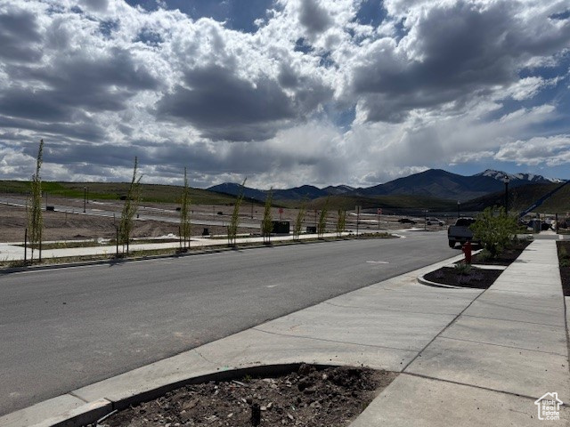 View of road with a mountain view, sidewalks, and curbs
