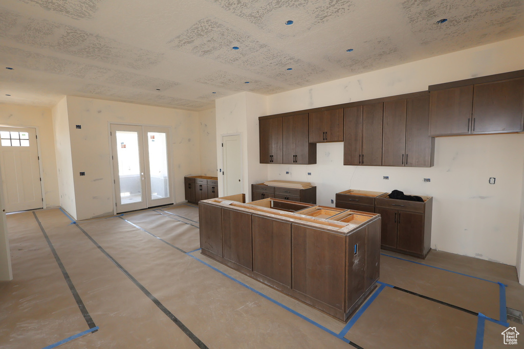 Kitchen featuring a kitchen island, dark brown cabinets, and french doors