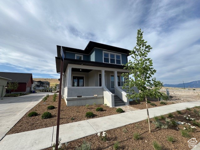View of front of home with a porch and concrete driveway