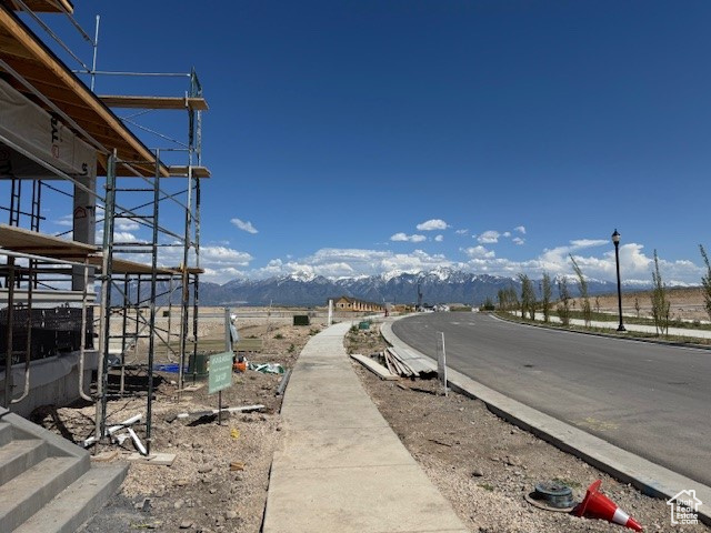 View of road featuring sidewalks, a mountain view, and street lighting