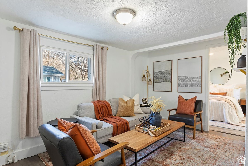 Living room with wood finished floors and a textured ceiling