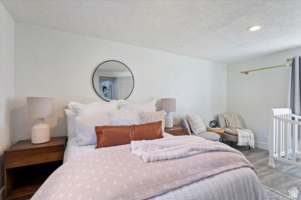 Bedroom featuring recessed lighting, wood finished floors, a textured ceiling, and baseboards