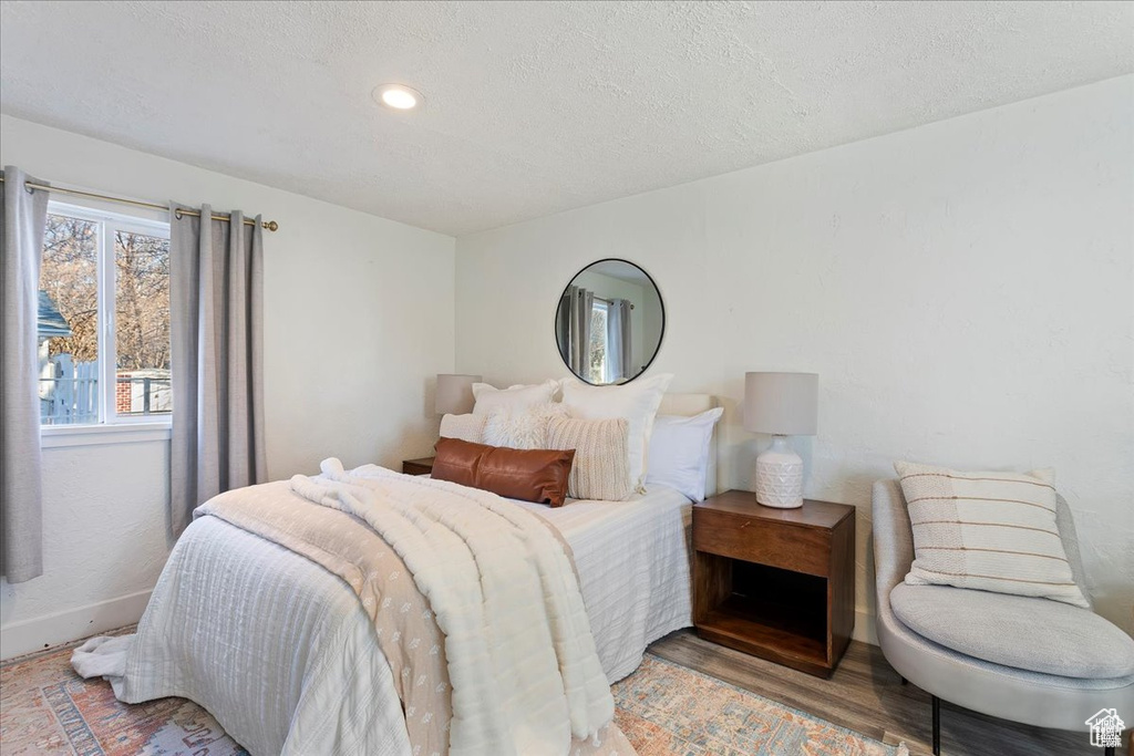 Bedroom featuring recessed lighting, wood finished floors, a textured ceiling, and baseboards
