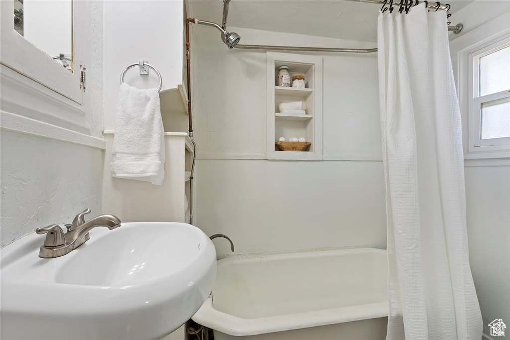 Full bath featuring shower / bath combination with curtain and a sink