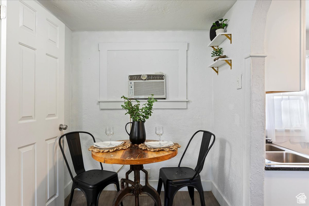 Dining area featuring an AC wall unit and baseboards