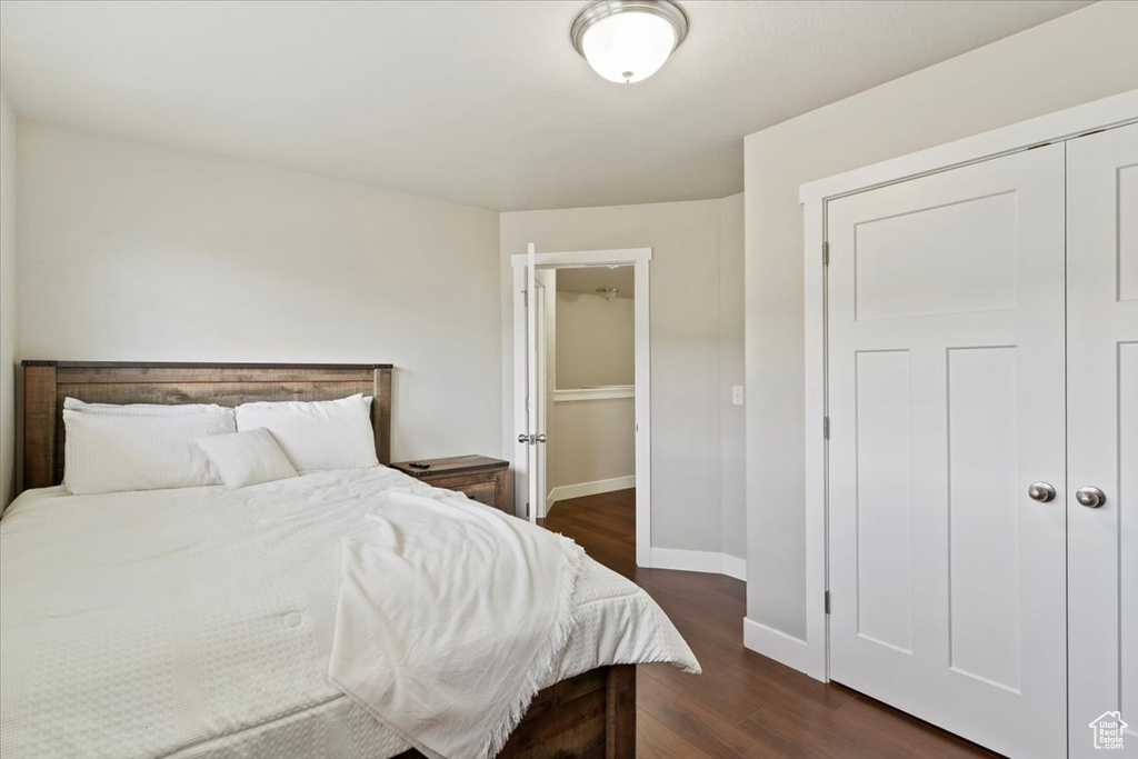 Bedroom featuring baseboards, wood finished floors, and a closet