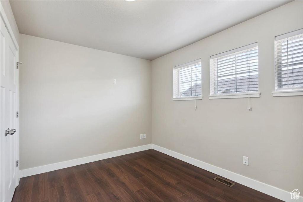 Spare room with baseboards and dark wood finished floors