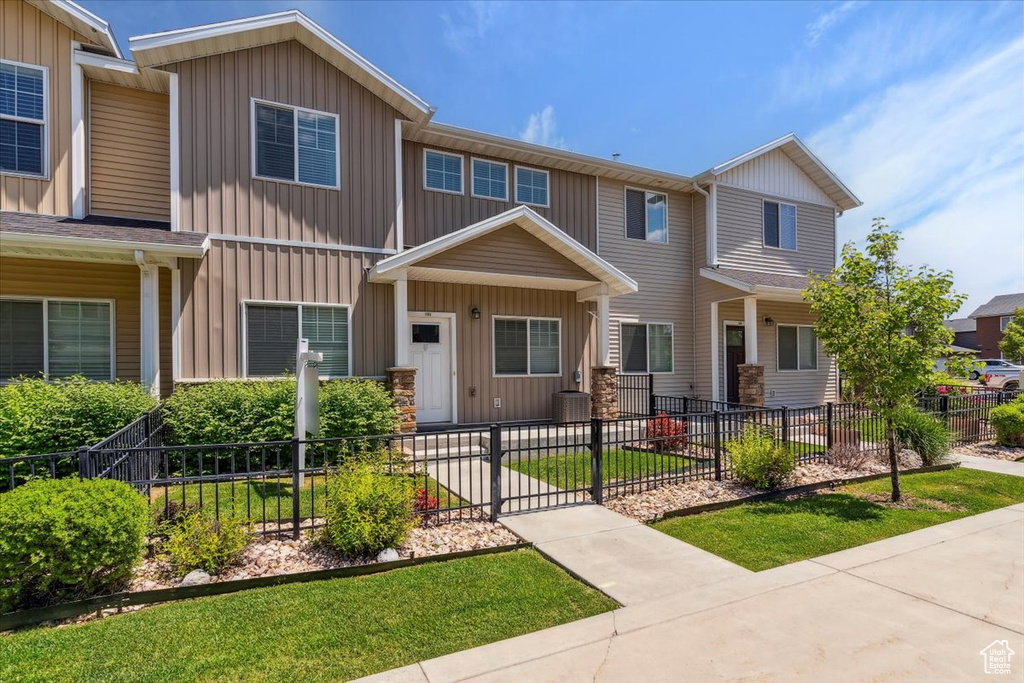 View of front of house featuring a fenced front yard and central AC