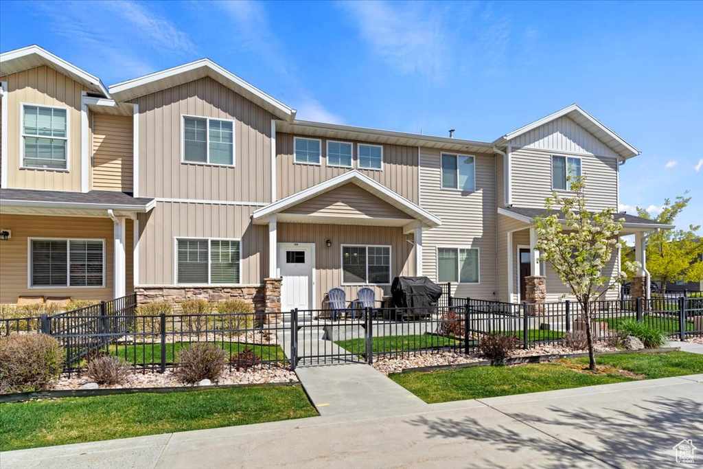 View of front of house with board and batten siding and a fenced front yard