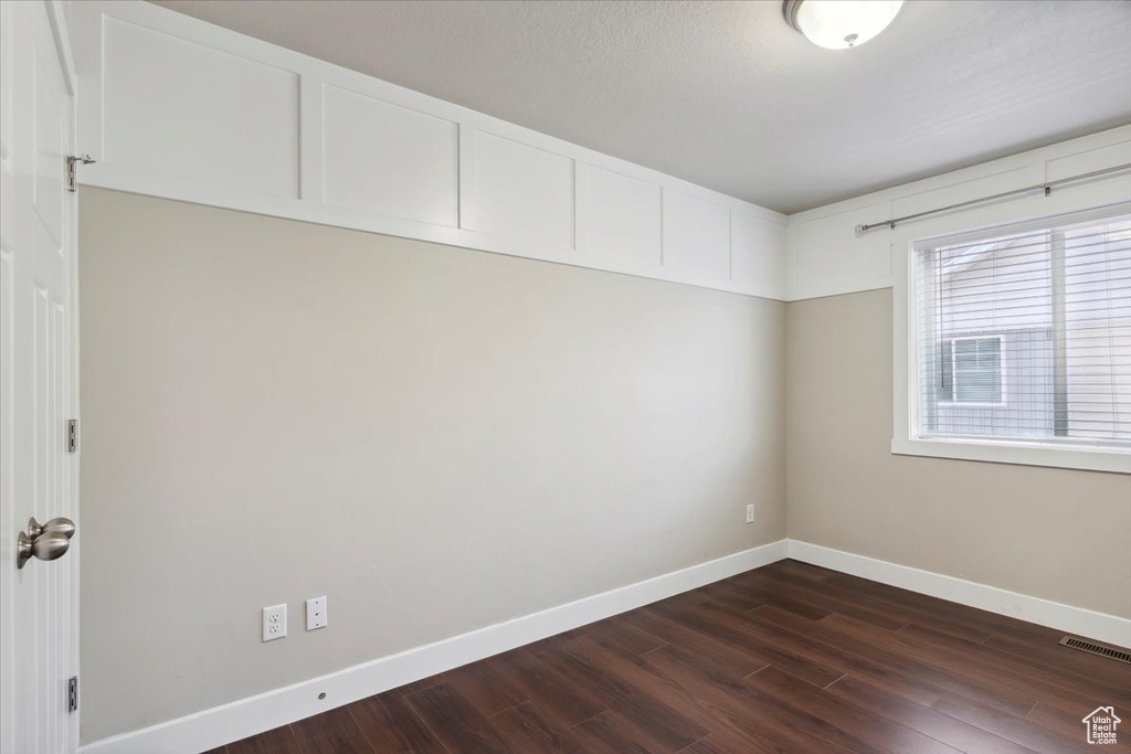 Unfurnished room with dark wood-style floors and baseboards