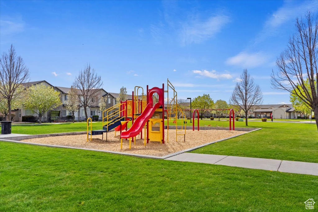 Community jungle gym with a residential view and a lawn