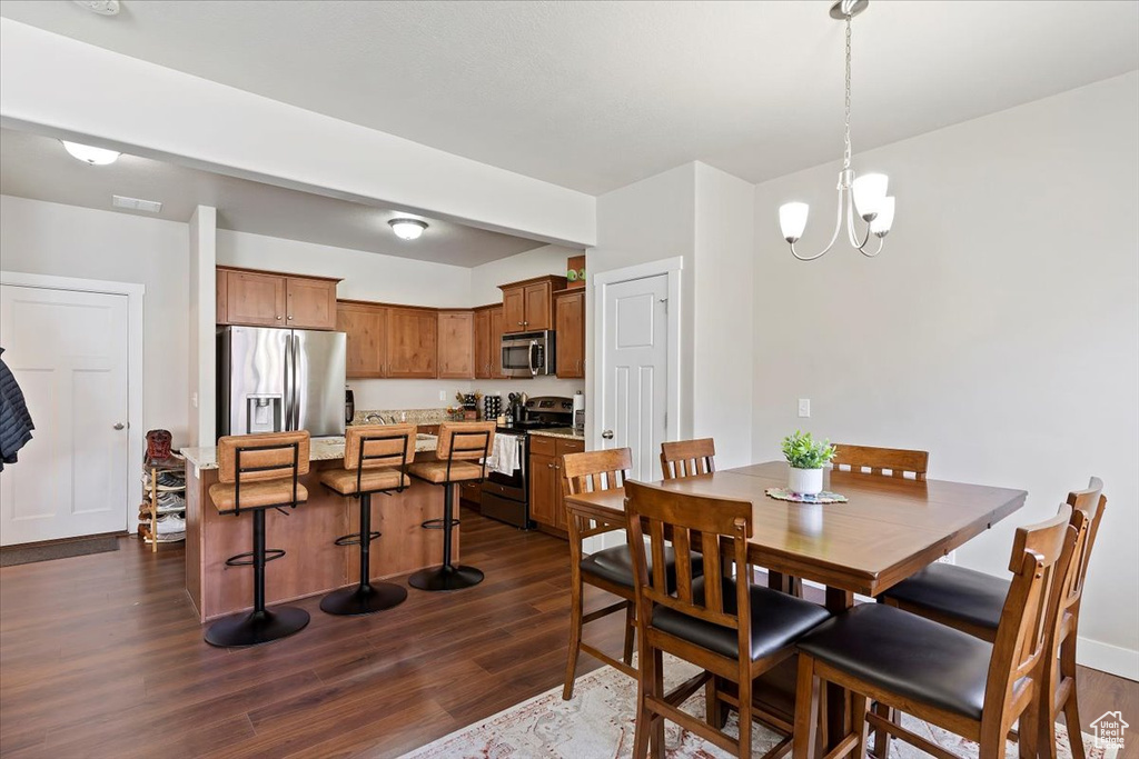 Dining area with an inviting chandelier, visible vents, and dark wood finished floors