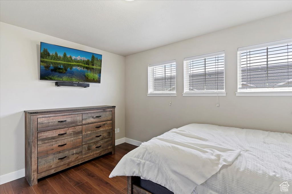 Bedroom with dark wood-type flooring and baseboards