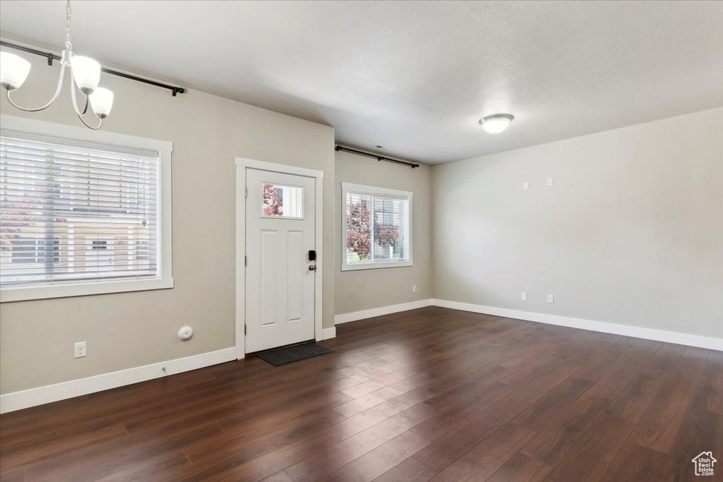 Foyer featuring a chandelier, dark wood finished floors, and baseboards