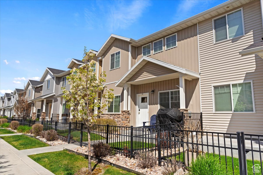 View of property with fence, board and batten siding, and a residential view