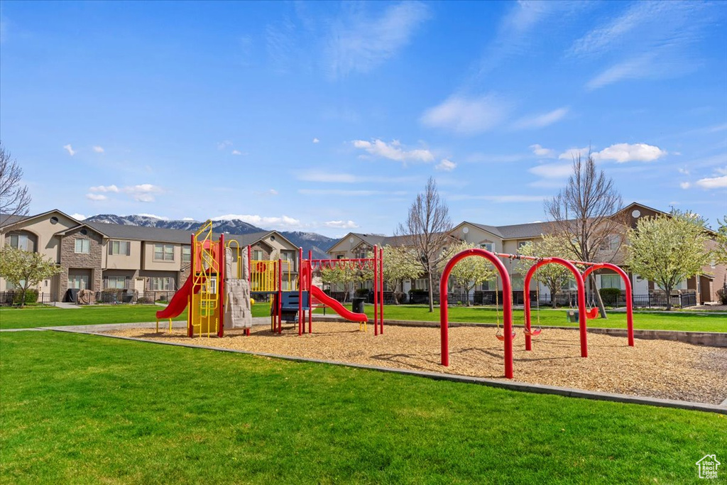 Community playground featuring a mountain view and a yard