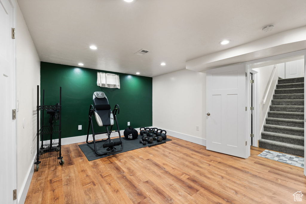 Exercise area with recessed lighting, baseboards, visible vents, and wood finished floors