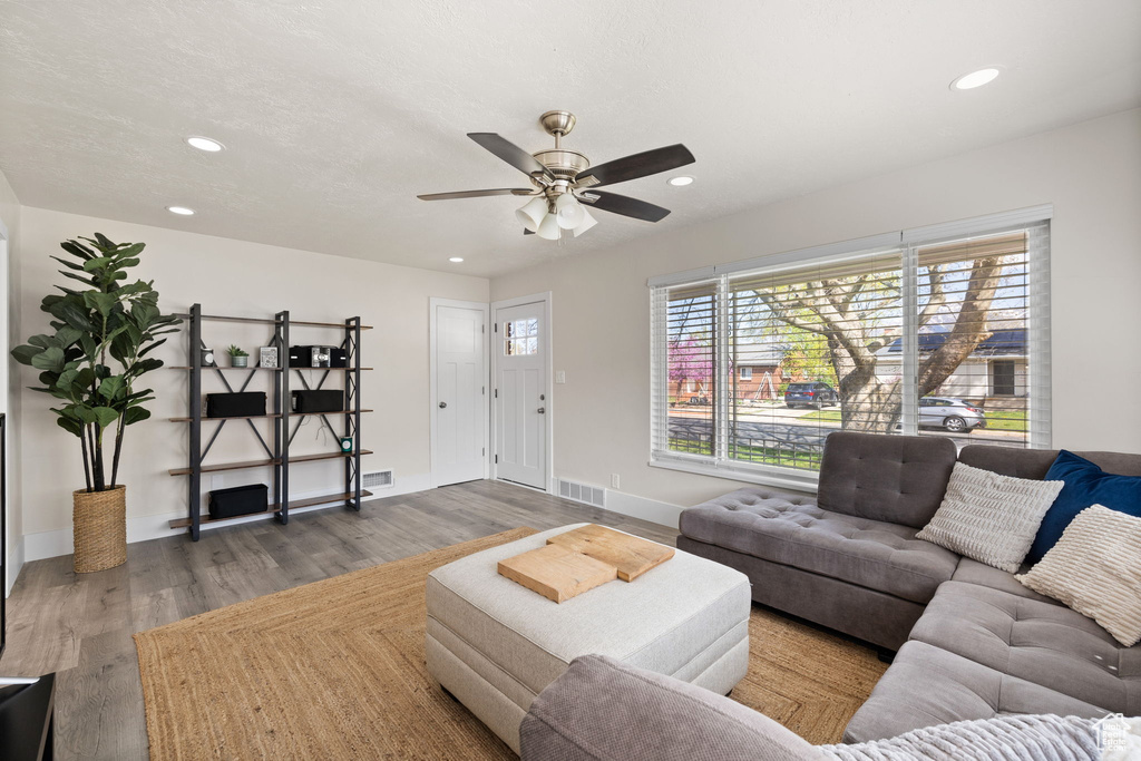 Living area with recessed lighting, ceiling fan, wood finished floors, and visible vents