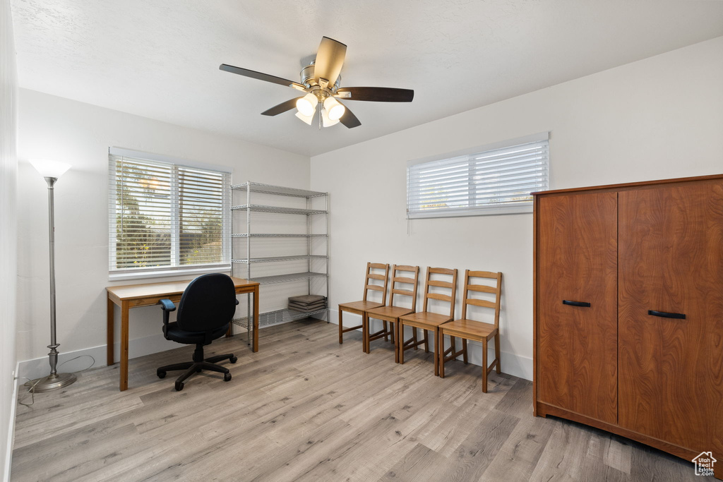 Office space with ceiling fan, baseboards, and light wood-style floors