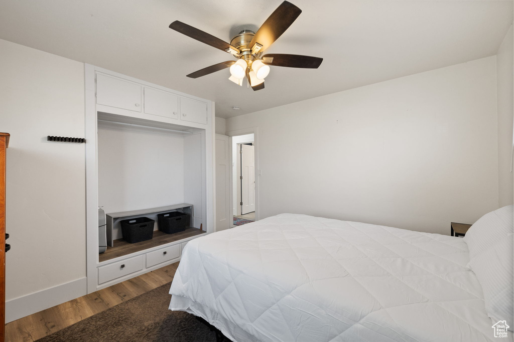 Bedroom with baseboards, a ceiling fan, wood finished floors, and a closet