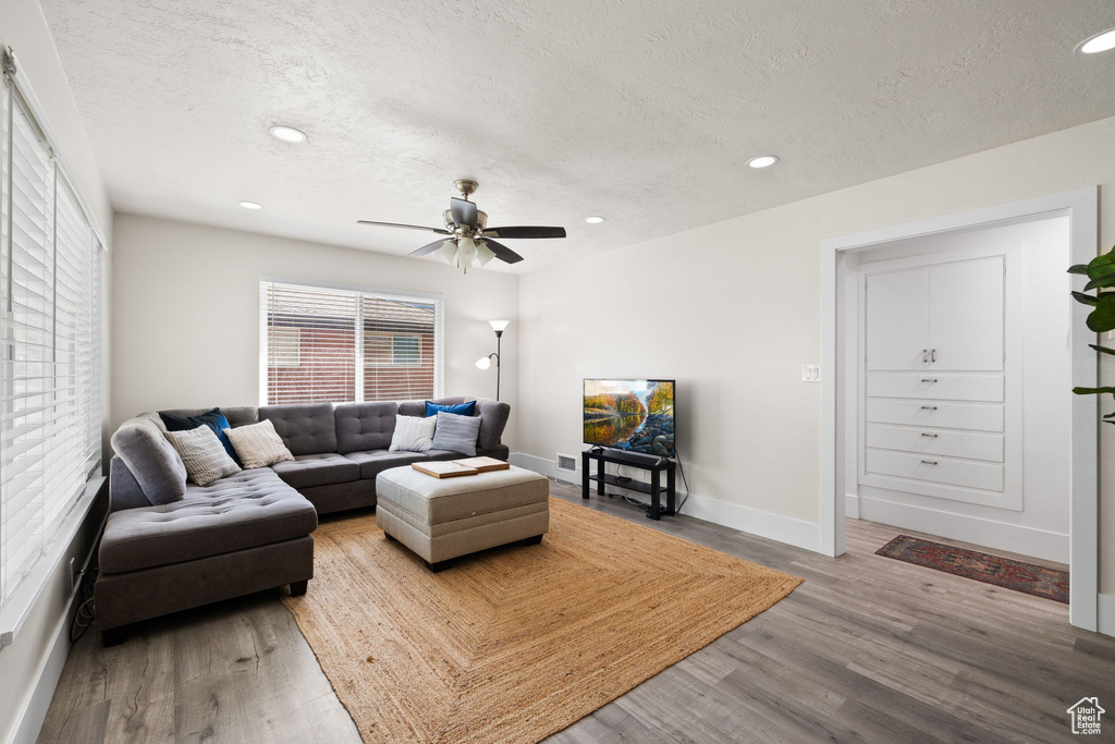 Living room featuring recessed lighting, a textured ceiling, and wood finished floors