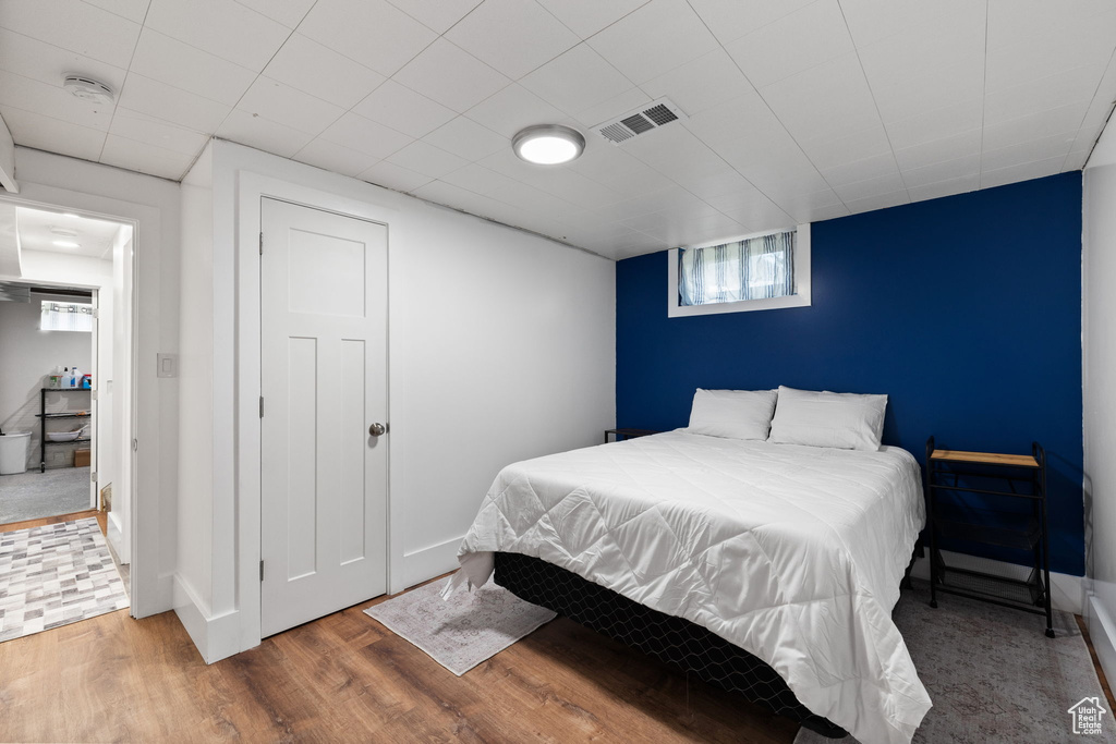 Bedroom featuring visible vents, baseboards, and wood finished floors