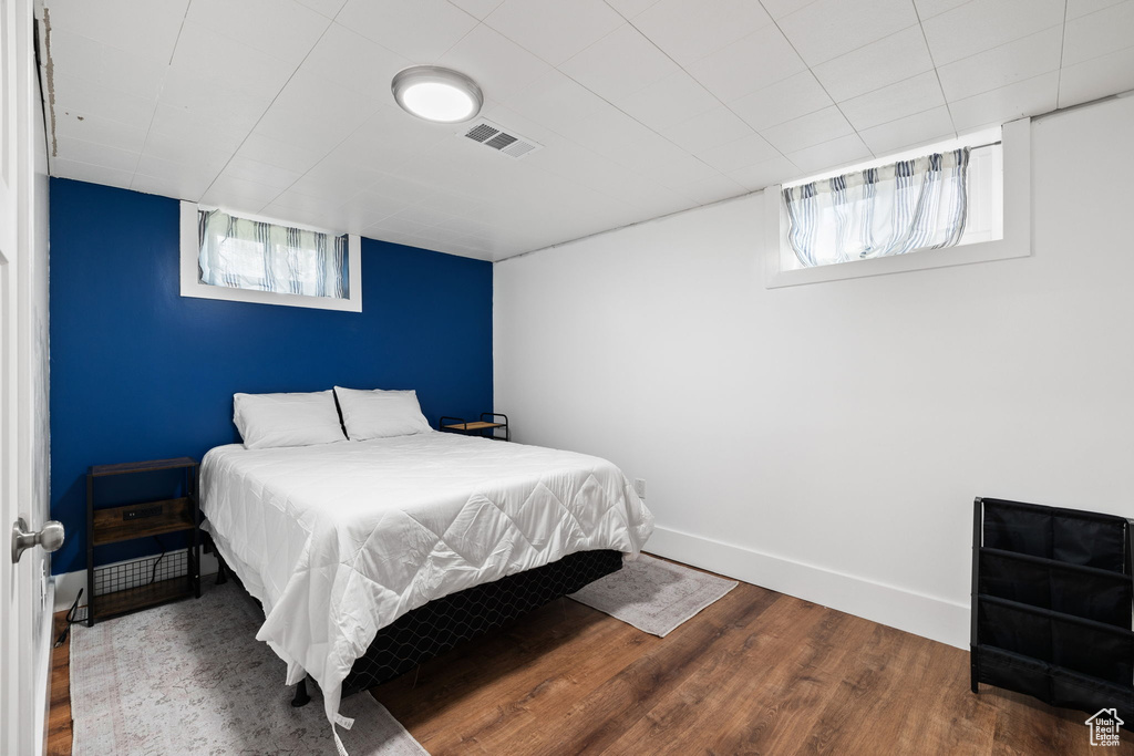 Bedroom with baseboards, wood finished floors, and visible vents