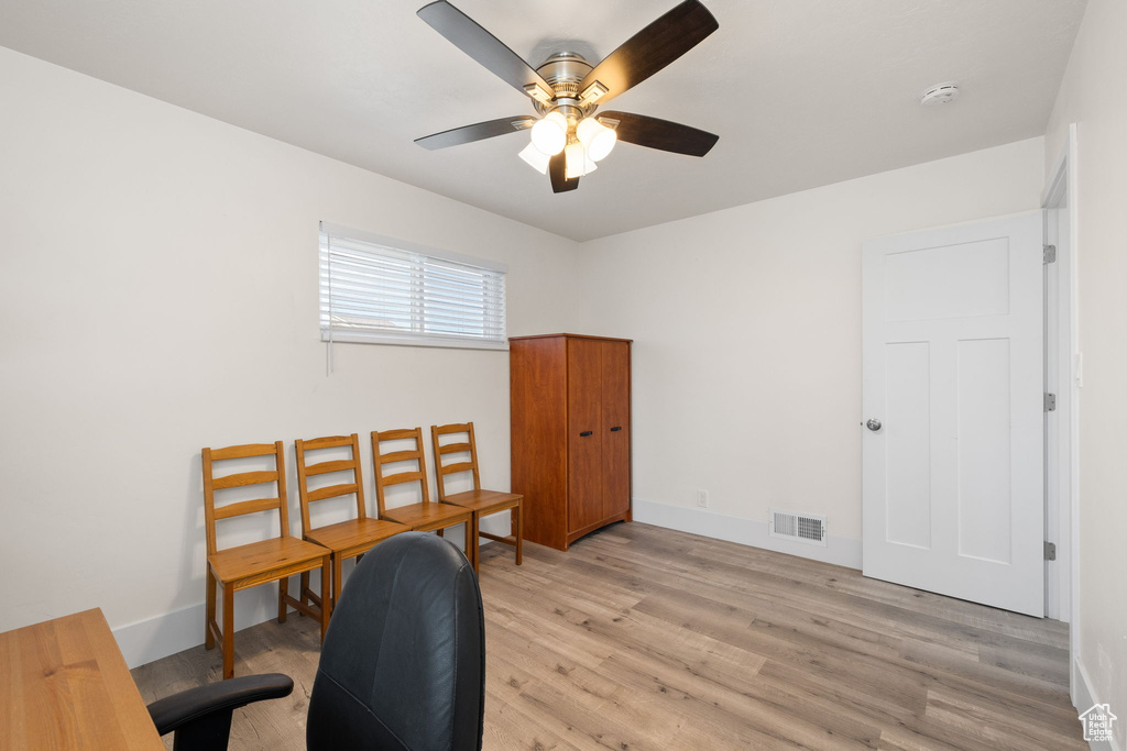 Office space featuring a ceiling fan, light wood finished floors, and visible vents