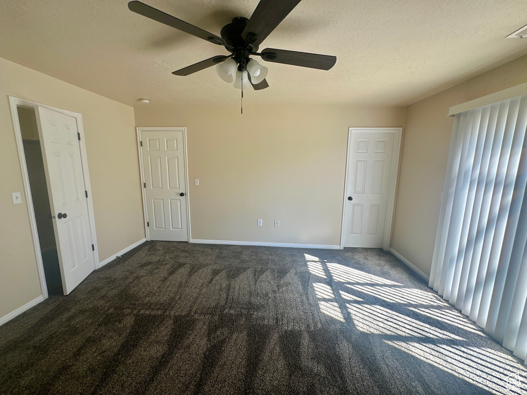 Unfurnished bedroom with baseboards, a textured ceiling, carpet, and ceiling fan