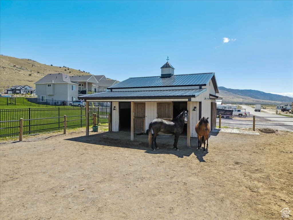 Rear view of house with an exterior structure, an outbuilding, a mountain view, and metal roof